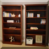 F09. Pair of wooden bookshelves. Each measures 6'h x 3'w x 1'd 
